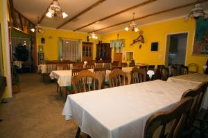un restaurante con mesas y sillas blancas y paredes amarillas en Tourist Farm Gregorič en Zalošče