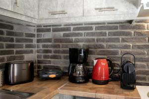a kitchen counter with appliances on a brick wall at Mikio Guest House in Kalabaka