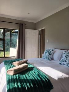a bedroom with a bed with towels on it at Ledges Retreat in Bergville +82 photos