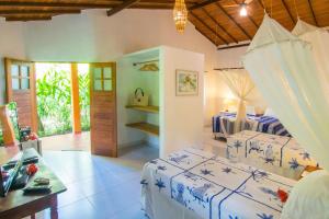 a bedroom with two beds and a desk in it at Pousada do Bosque in Trancoso