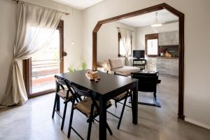 a dining room with a table and chairs and a living room at Mikio Guest House in Kalabaka