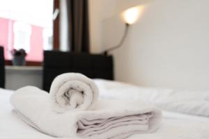 a white towel sitting on top of a bed at Apartment Central - Free parking - 5 people - 3 rooms - 3 TVs - boxspring - wifi in Bremen +18 photos