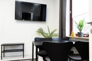 a dining room with a table with chairs and a television on the wall at Apartment Central - Free parking - 5 people - 3 rooms - 3 TVs - boxspring - wifi in Bremen