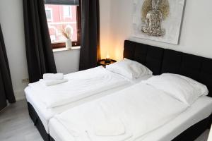 a bedroom with two beds with white sheets and a window at Apartment Central - Free parking - 5 people - 3 rooms - 3 TVs - boxspring - wifi in Bremen