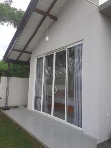 a screened in porch of a white house at Sathmani One in Nikawatawana