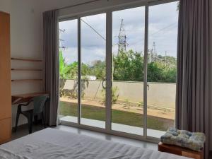 a bedroom with a large window with a view of a street at Sathmani One in Nikawatawana +1 photo