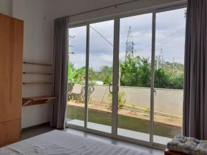 a bedroom with a large window with a view of a road at Sathmani One in Nikawatawana