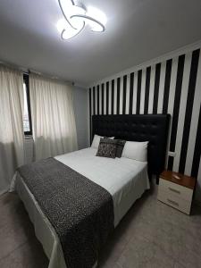 a bedroom with a bed with a black and white striped wall at IL COLOSSEO B&B CASSINO in Cassino