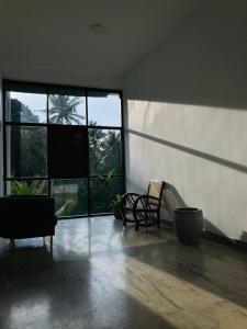 an empty room with two chairs and large windows at Emerald Mountain Resort in Ampitiya
