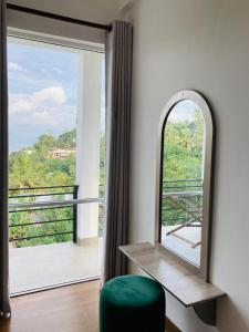 a room with a green chair and a large window at Emerald Mountain Resort in Ampitiya