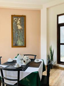 a dining room with a table and a painting on the wall at Emerald Mountain Resort in Ampitiya