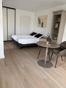 a bedroom with a bed and a table and chairs at B&B Witvliet, kamers en studio met heerlijk ontbijt ! in Zoutelande