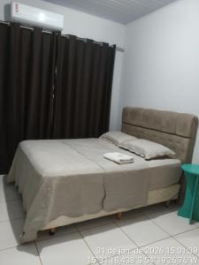 a bedroom with a bed and a black curtain at CASA FLORENÇA 2,2 km do Lago municipal in Primavera do Leste