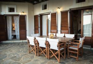 a wooden table and chairs on a patio at Villa Sophia in Andros