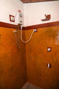 a bathroom with a shower with a hair dryer on the wall at Comfort Treehouse Pidurangala in Dambulla +21 photos
