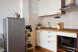 a kitchen with white cabinets and a refrigerator at La Casa Di Gianni - Vista Mare in Ospedaletti