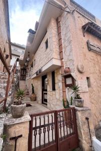a stone building with a gate and potted plants at Stone house Anogeia in Anogeia