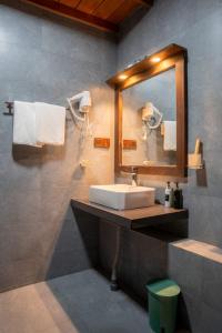 a bathroom with a sink and a mirror at Monsoon Cabana Ella in Ella