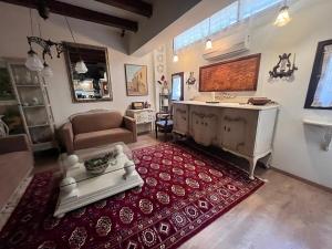a living room with a kitchen and a living room with a red rug at Stone house Anogeia in Anogeia
