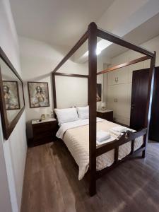 a bedroom with a canopy bed with white sheets at Stone house Anogeia in Anogeia
