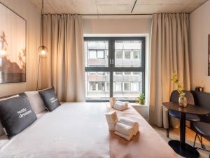 a large bed in a room with a large window at Limehome Düsseldorf Stresemannstraße - Digital Access in Düsseldorf +43 photos