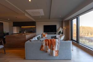 a living room with a couch and a kitchen at The 1898 Niseko in Kutchan