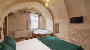 a bedroom with a bed and a bath tub at Zula Cave House in Ürgüp +16 photos