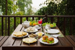 a wooden table with plates of food on it at Monsoon Cabana Ella in Ella