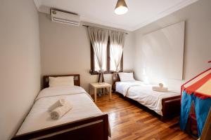 a bedroom with two beds and a window at Mikio Guest House in Kalabaka