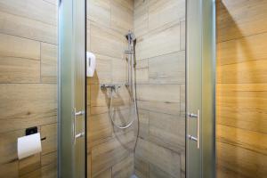 a shower in a bathroom with wooden walls at Birdhouse in Prešov +58 photos