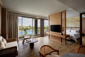 a hotel room with a bed and a tv at Myze Hotel Waingapu in Waingapu