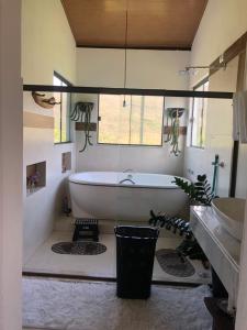 a bathroom with a tub and a sink at Casa Águas Claras in Palmeiras +6 photos