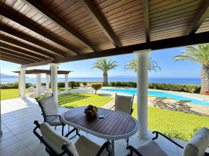 a patio with a table and chairs and a pool at Villa Ermis Spartia Kefalonia in Spartià