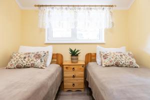two beds in a room with a window at Yellow House in Pilipets +54 photos