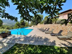 a villa with a swimming pool and a stone wall at Casa rural Masia Les Apieres. in El Pla de Manlleu