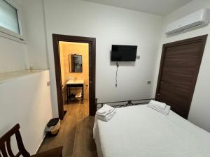 a bedroom with a bed and a television on the wall at B&B Annunziata- In centro, vicino all' Ospedale di Cosenza in Cosenza