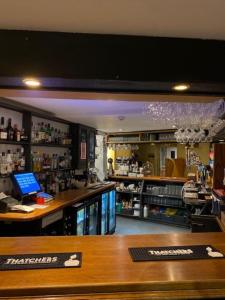 a bar in a pharmacy with a laptop on a counter at The Ilchester Arms Hotel, Ilchester Somerset in Ilchester