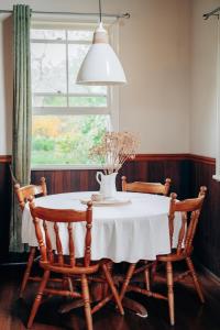 a dining room table with a vase of flowers on it at Breathe Glenrock Gardens in Tenterfield