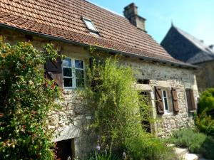 ein altes Steinhaus mit rotem Dach in der Unterkunft grange cavanet in Goulles