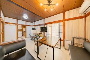 a room with a table and chairs and a television at Soresta INN Shinozaki in Tokyo