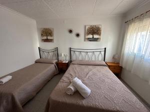two beds in a bedroom with towels on the floor at La Marquesa - CA L'ONA in Poblenou del Delta