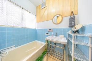 a bathroom with blue tiles and a sink and a tub at Soresta INN Shinozaki in Tokyo +28 photos