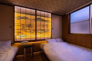 a bedroom with two beds and a window with a view at Soresta INN Shinozaki in Tokyo