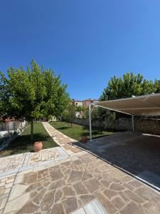 a patio with an umbrella and trees in a yard at Sani Luxury Pool Villa in Sani Beach