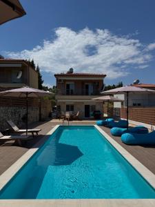a swimming pool in front of a house at Sani Luxury Pool Villa in Sani Beach