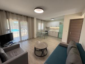 a living room with a couch and a table and a kitchen at Sani Luxury Pool Villa in Sani Beach