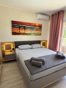 a bedroom with a bed with a painting on the wall at Sani Luxury Pool Villa in Sani Beach +29 photos