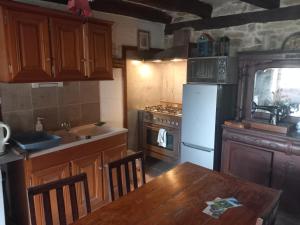 eine Küche mit einem Holztisch und einem weißen Kühlschrank in der Unterkunft grange cavanet in Goulles