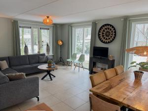 a living room with a couch and a table at Bospark Garderen in Garderen