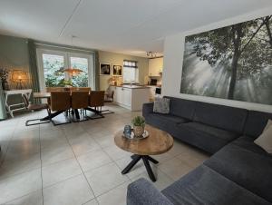 a living room with a couch and a table at Bospark Garderen in Garderen